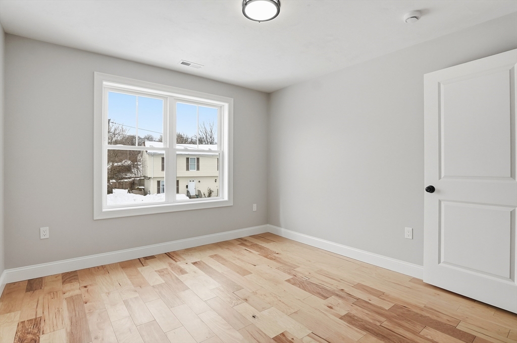 12 Benham Street Worcester, MA 01604 - Photo 24 of 26 a view of an empty room with a window and wooden floor