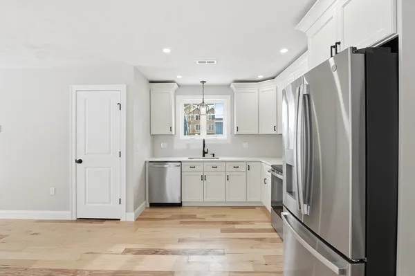 a large kitchen with a refrigerator and a sink