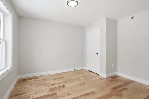 a view of empty room with wooden floor