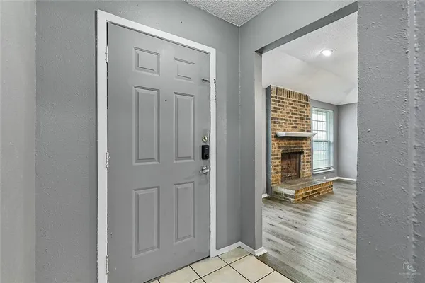 a view of a hallway with wooden floor and a bathroom