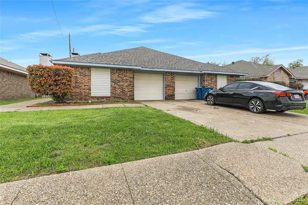 a front view of a house with a garden and yard