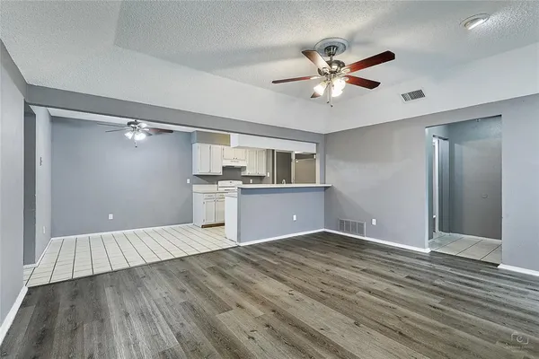 a view of a livingroom with a ceiling fan wooden floor and window