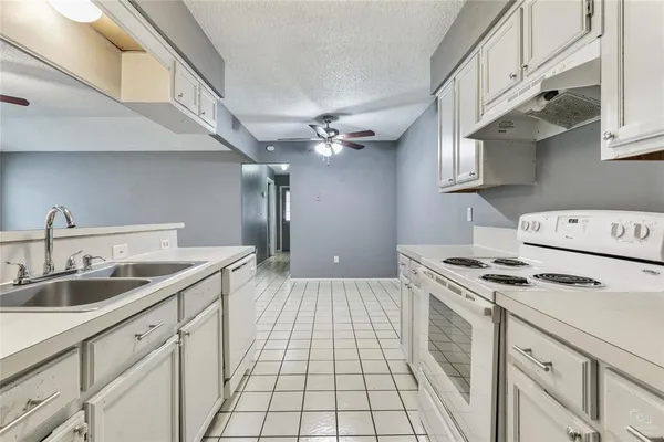 a kitchen with a sink stove and cabinets