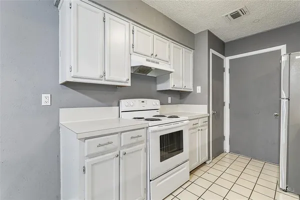 a kitchen with white cabinets and white appliances