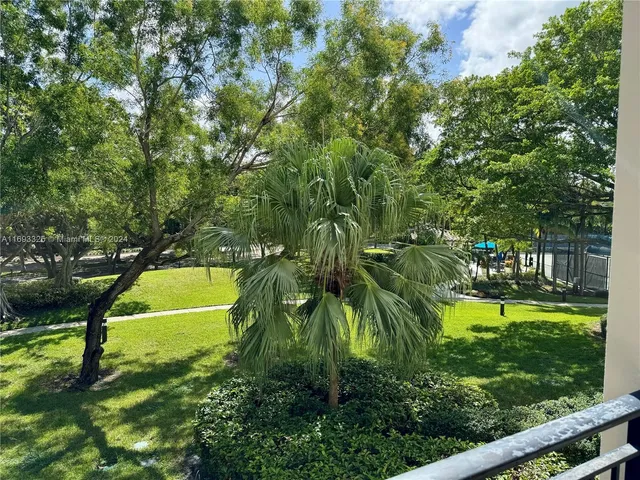 a view of a swimming pool with a yard and large trees