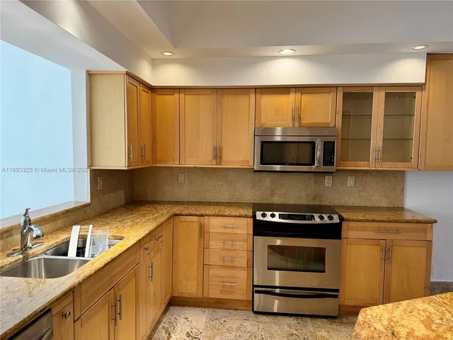 a kitchen with granite countertop a sink and stainless steel appliances