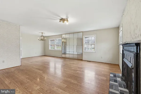 a view of an empty room with a fireplace and a window