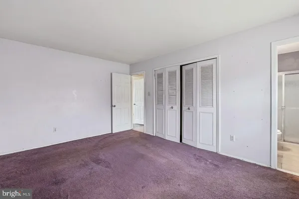 a view of an empty room and closet area