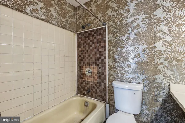 a bathroom with a granite countertop toilet a sink and a mirror