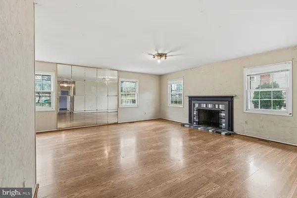 an empty room with windows and fireplace
