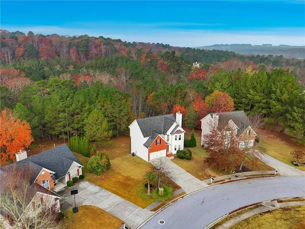 an aerial view of a house with a garden and lake view