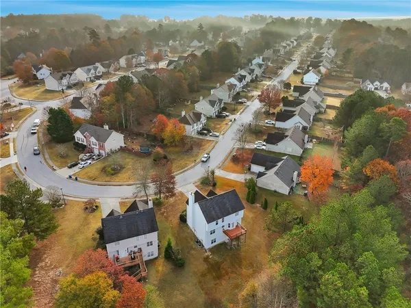 an aerial view of a house with swimming pool and large trees