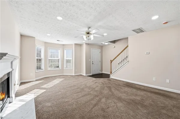 a view of an empty room with a fireplace and a window