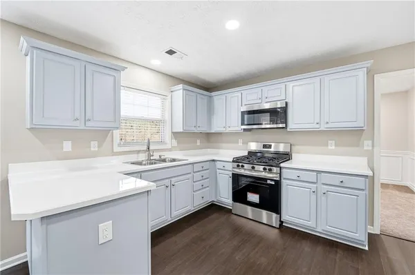 a kitchen with sink a microwave and cabinets