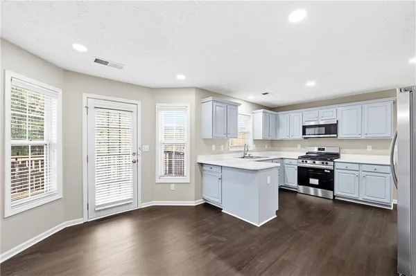 a open kitchen with granite countertop a stove top oven sink and cabinets