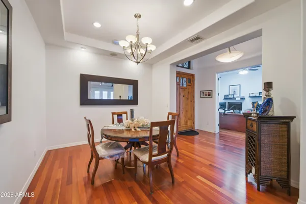 a view of a dining room with furniture a chandelier and wooden floor