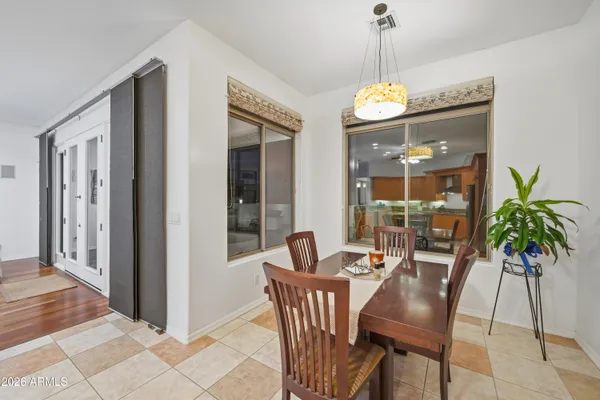 a dining room with furniture potted plants and wooden floor