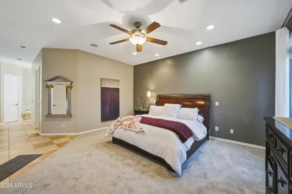 a spacious bedroom with a large bed and a chandelier
