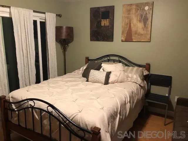 a bedroom with a bed and a painting on the wall