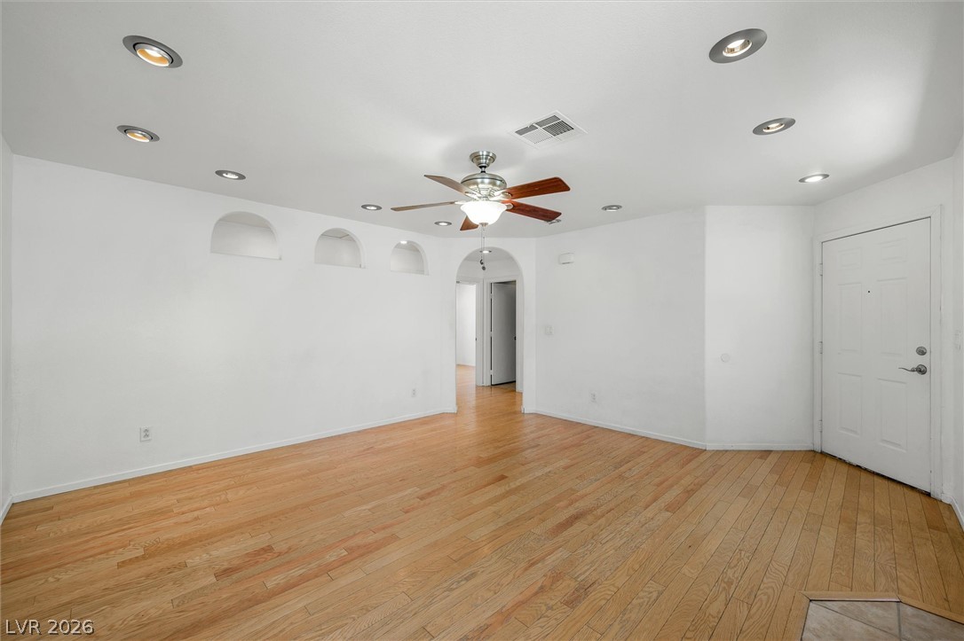6762 Arapaho Ranch Las Vegas, NV 89148 - Photo 9 of 27 Recessed lighting illuminates this bright, open-plan living area with hardwood floors and elegant arched wall niches.