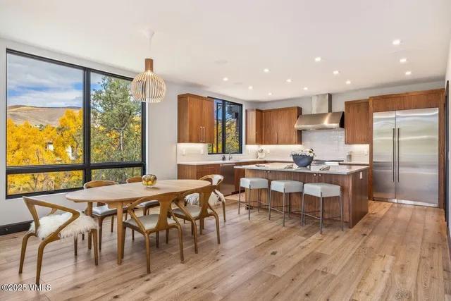 a kitchen with stainless steel appliances granite countertop a sink a stove a refrigerator a table and chairs