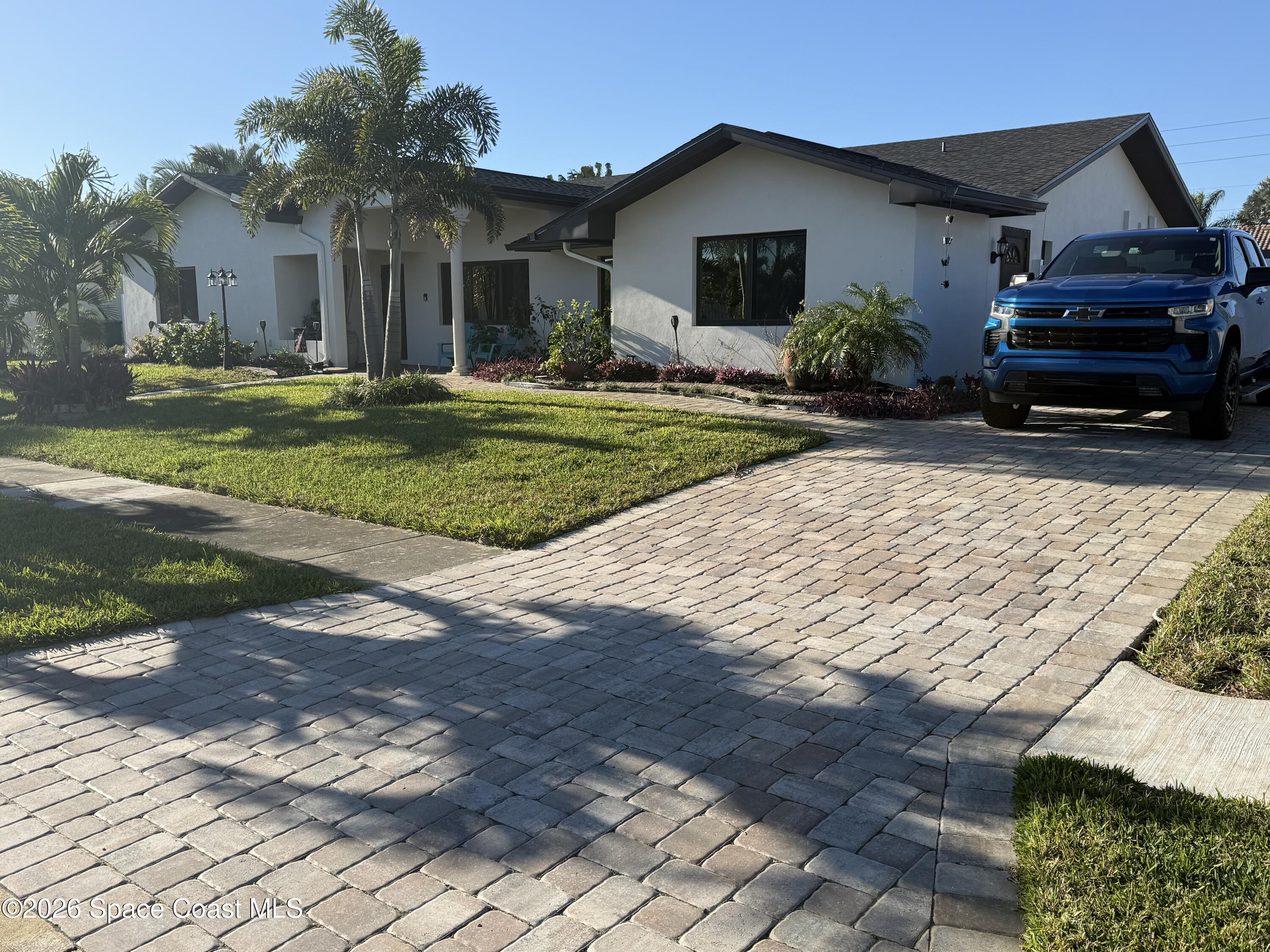 1908 Cedar Lane Melbourne Beach, FL 32951 - Photo 2 of 52 a front view of a house with a yard and garage