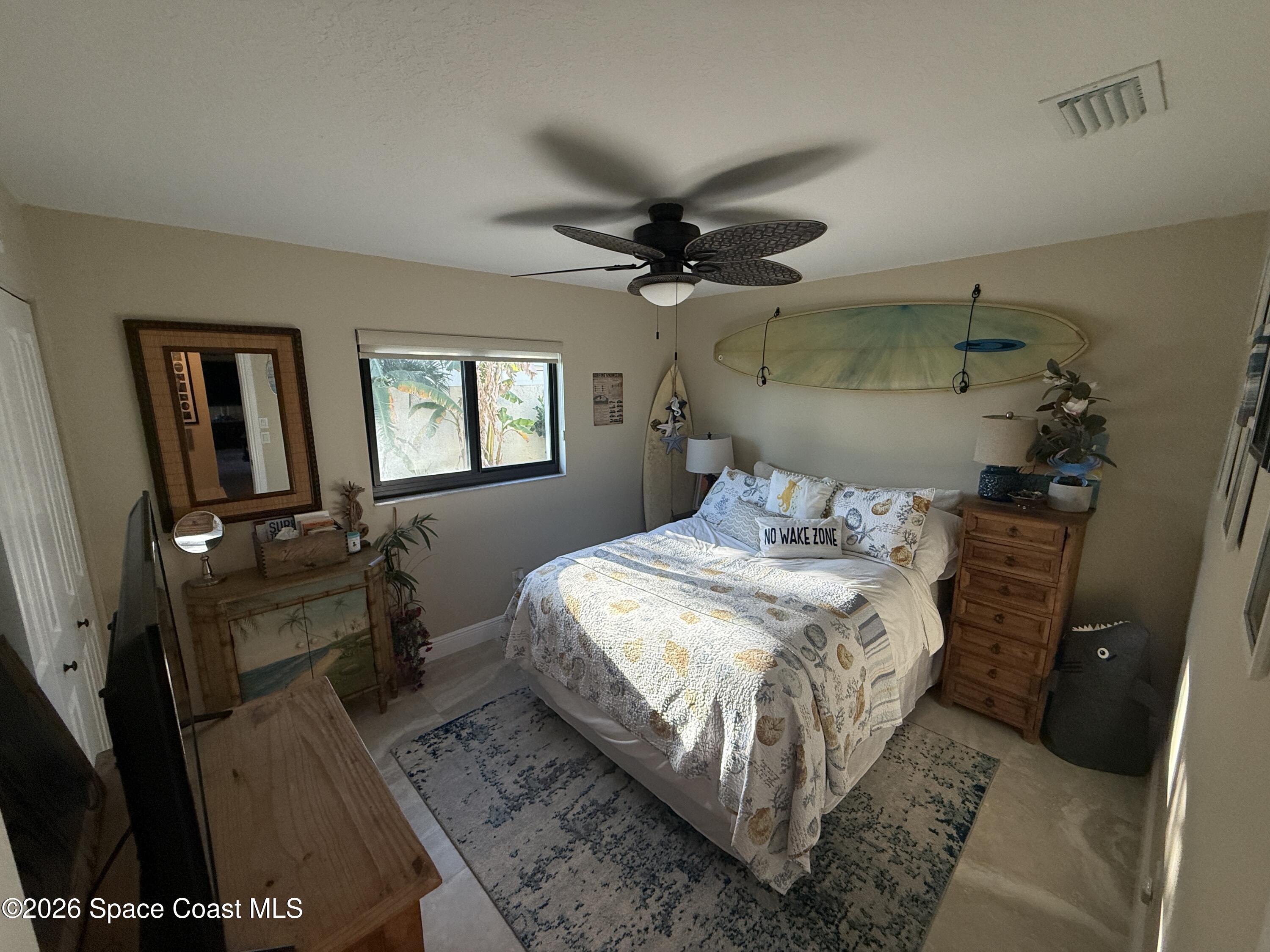 1908 Cedar Lane Melbourne Beach, FL 32951 - Photo 27 of 52 a bedroom with a bed a mirror on the dresser and a chandelier
