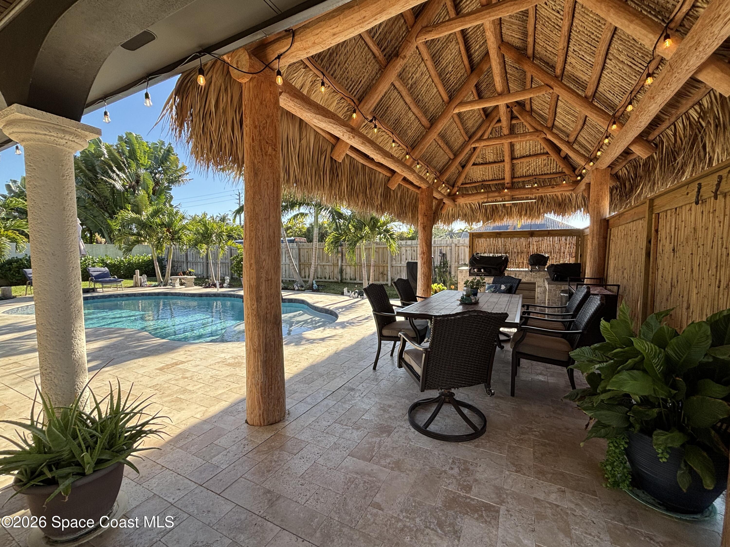1908 Cedar Lane Melbourne Beach, FL 32951 - Photo 7 of 52 a view of a patio with table and chairs potted plants with palm trees