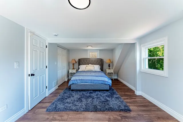 a view of a hallway with wooden floor and a rug