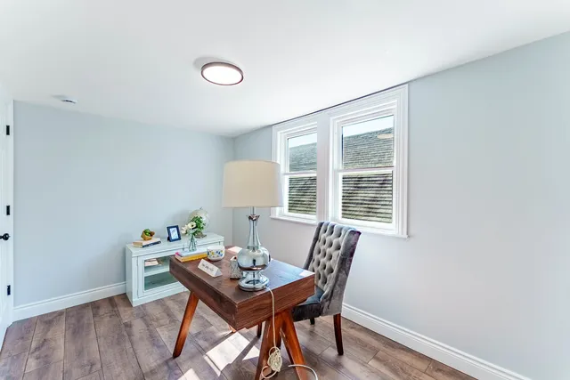 a view of a workspace with furniture and a window