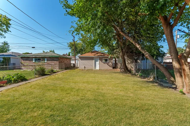 a view of a house with backyard and tree