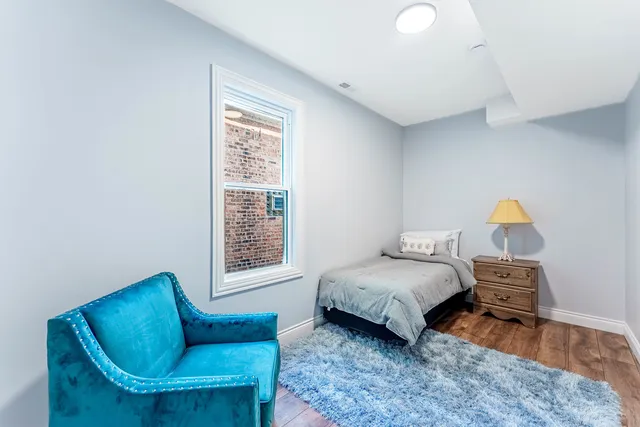 a bedroom with bed couch and window