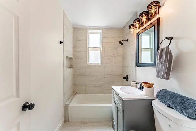 a bathroom with a tub sink and mirror