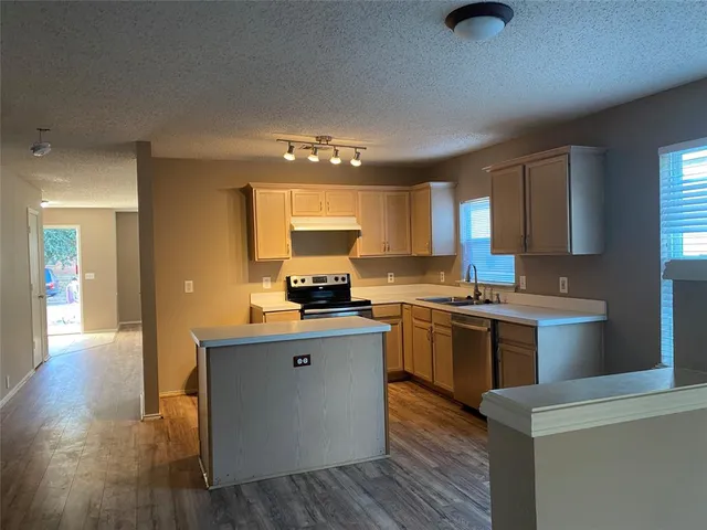 a kitchen with a sink cabinets and wooden floor