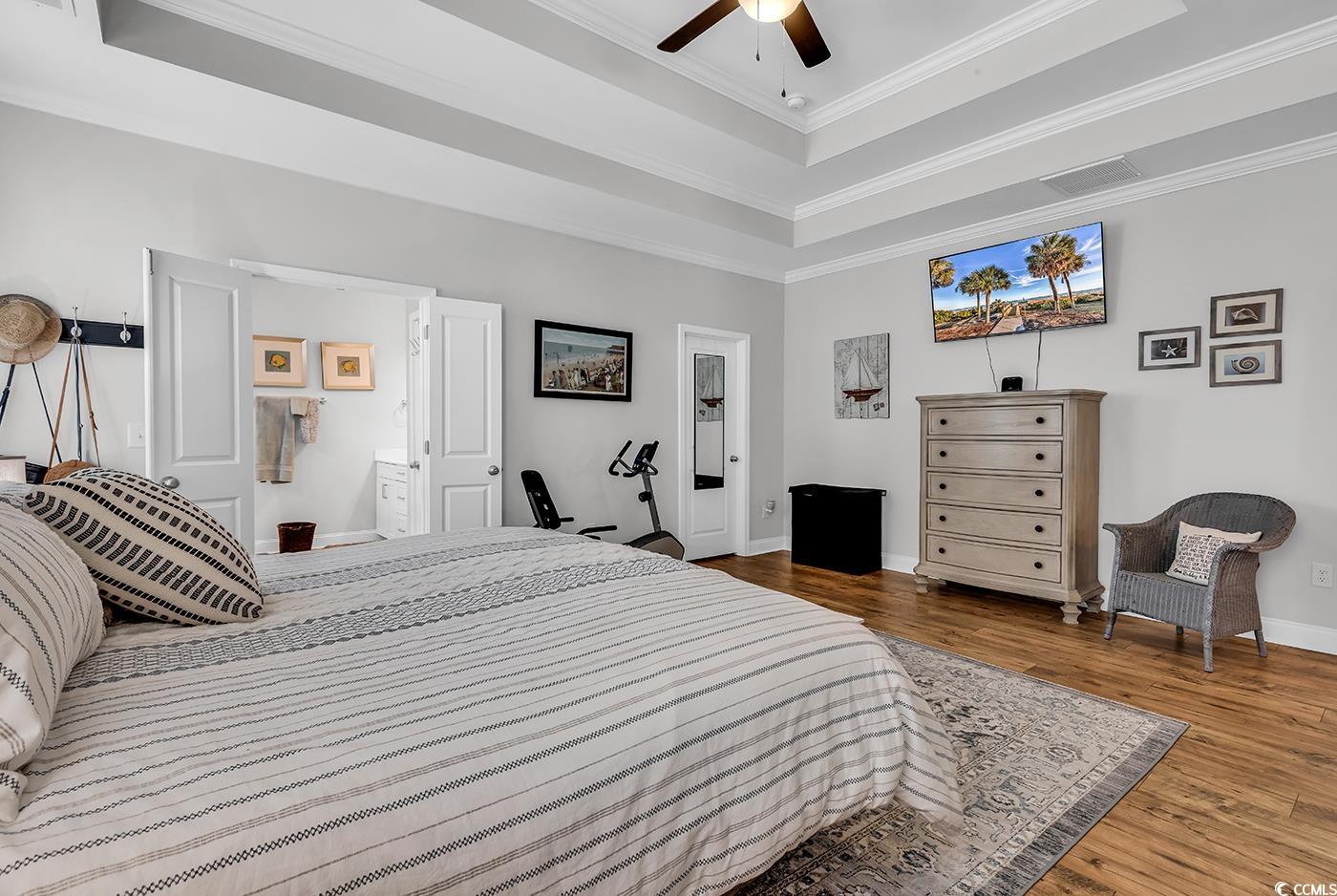 6024 Curran Street Murrells Inlet, SC 29576 - Photo 15 of 34 Bedroom with a tray ceiling, crown molding, dark wood-type flooring, and a ceiling fan