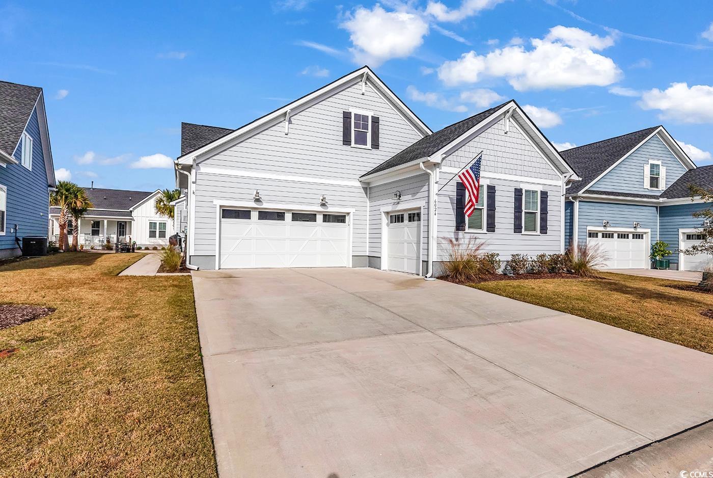 6024 Curran Street Murrells Inlet, SC 29576 - Photo 26 of 34 Traditional-style home with a front lawn, a garage, driveway, and roof with shingles