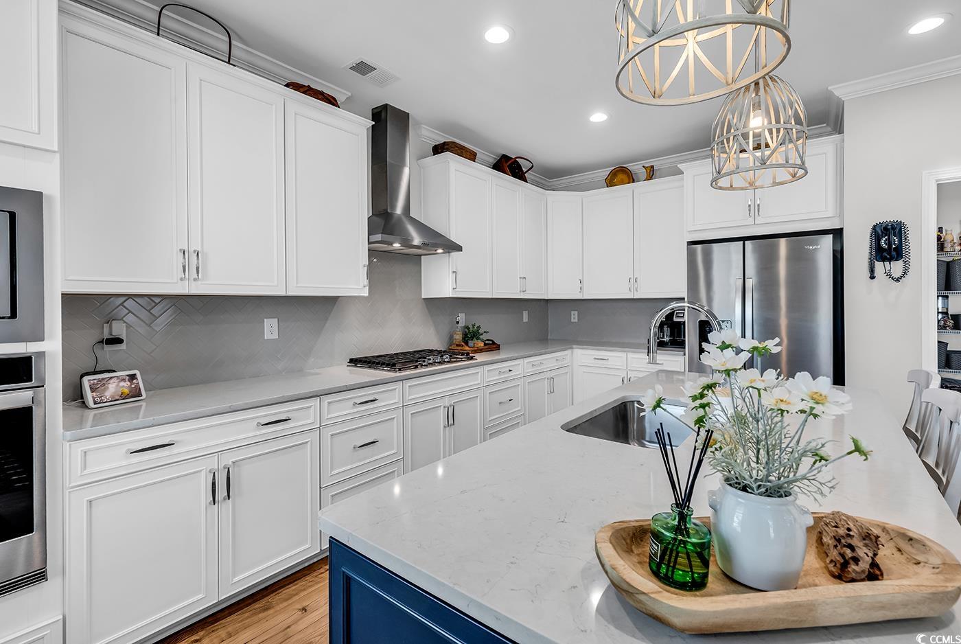6024 Curran Street Murrells Inlet, SC 29576 - Photo 7 of 34 Kitchen featuring light stone counters, appliances with stainless steel finishes, recessed lighting, white cabinets, and ornamental molding