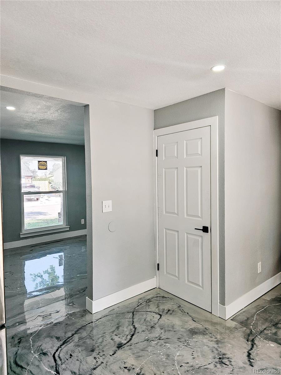 4716 Freeport Way Denver, CO 80239 - Photo 24 of 29 a view of a hallway with wooden floor and a refrigerator