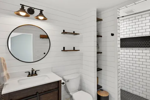 a bathroom with a sink a toilet and shower
