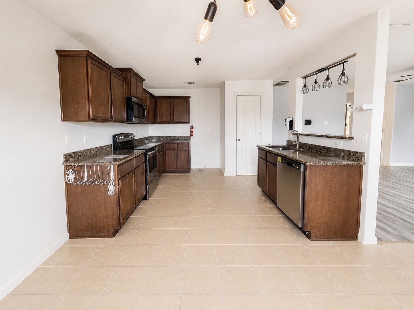 341 Comanche Plains Road La Marque, TX 77568 - Photo 5 of 17 a kitchen with stainless steel appliances granite countertop a stove top oven a sink dishwasher and a refrigerator with wooden cabinets