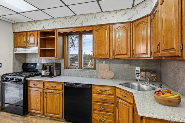 a kitchen with stainless steel appliances granite countertop a sink a stove and cabinets