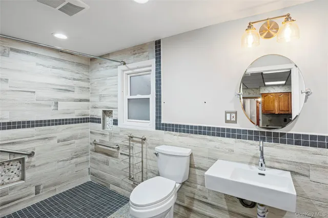 a bathroom with a sink a toilet and mirror