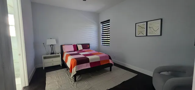 a bedroom with a bed and a lamp on dresser