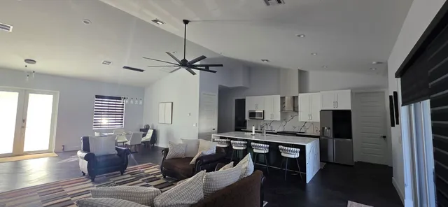 a living room with furniture a flat screen tv and kitchen view