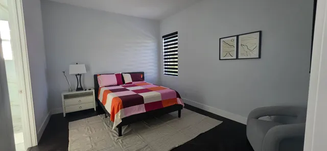 a bedroom with a bed a window and a chandelier