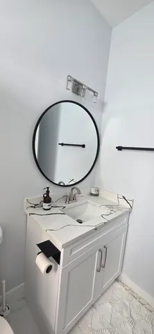 a kitchen with a stove a sink and a flat screen tv