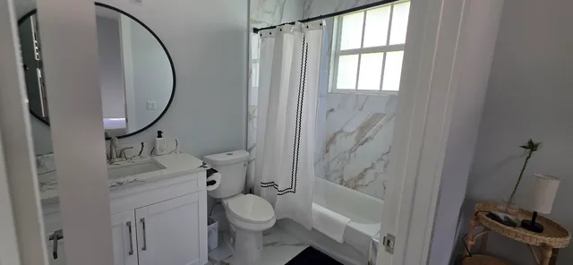 a bathroom with a granite countertop sink toilet and shower