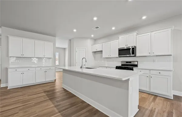 a kitchen with granite countertop white cabinets and white appliances