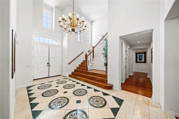 a view of entryway with a chandelier and front door
