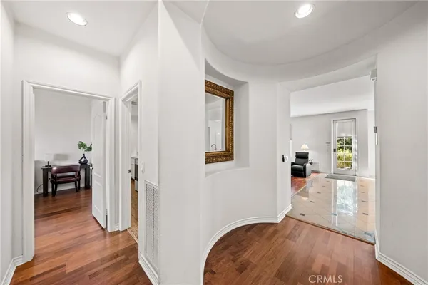 a view of a hallway with wooden floor and a living room
